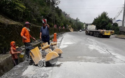 <p><strong>EASING TRAFFIC FLOW.</strong> Tuba town police chief, Inspector James Acod, examine an area of Marcos Highway in the Cordillera, as workers of the Department of Public Works and Highways (DPWH) do repair works at the accident-prone section of the road in Sitio Badiwan, Barangay Poblacion, Tuba Benguet. The Tuba police starts implementing on July 9 a “no parking” policy on both sides of this part of Marcos Highway. <em>(Photo courtesy of Tuba Police)</em></p>